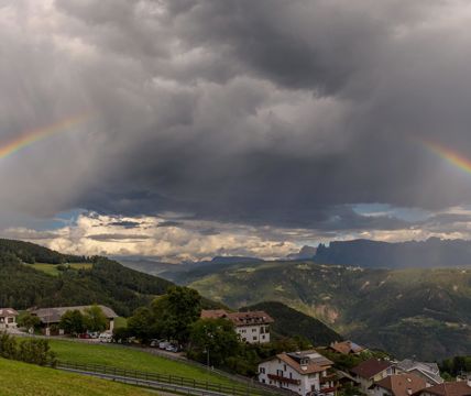 Nuvole e un arcobaleno sopra San Genesio
