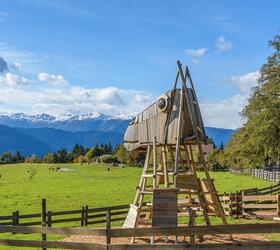 Grande struttura da gioco in legno a forma di testa di cavallo su un prato con panorama montano.