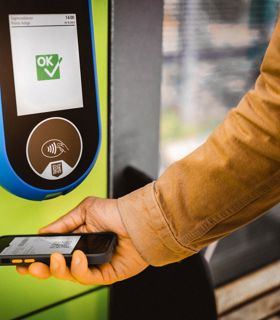 Convalida del biglietto con smartphone su lettore verde, display con conferma “OK”.