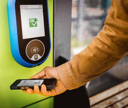 Convalida del biglietto con smartphone su lettore verde, display con conferma “OK”.